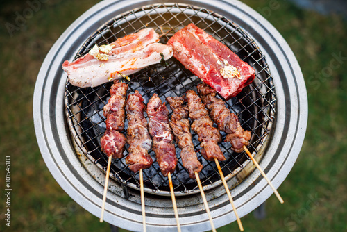 top view skewers meat ribs and sausage barbecue grilled on the grill in camping party outdoor © nutt
