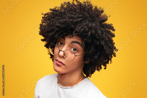 Young black skeptical man looking suspicious, having some doubt, orange panorama background with empty space photo