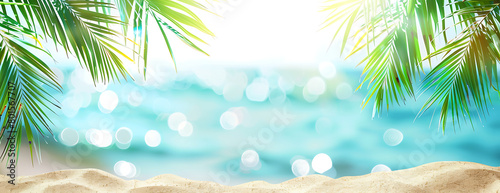 Summer background with tropical palm leaves and sandy beach background banner for summer vacation travel concept © Miftakhul Khoiri
