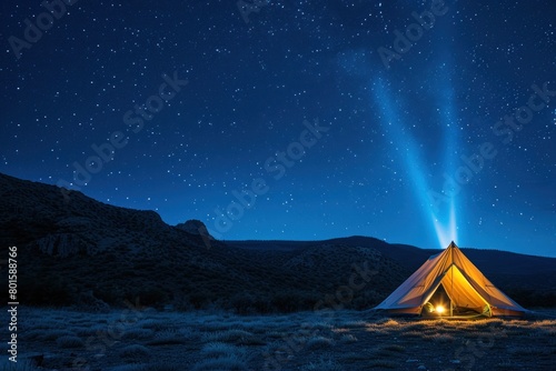 A small tent is lit up in the dark, with a bright light shining on it. The scene is set in a vast, empty field, with a clear sky above