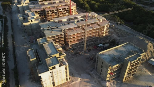 Drone view of large construction site for one more new hotel complex with large panoramic on Sunset located along seashore in Punta Cana, Dominican Republic. Noval. Tower crane, excavator and sand.  photo