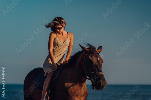 Stylish female riding her horse on a beach during sunset