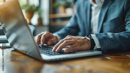 Man Typing on Laptop Computer on Wooden Table