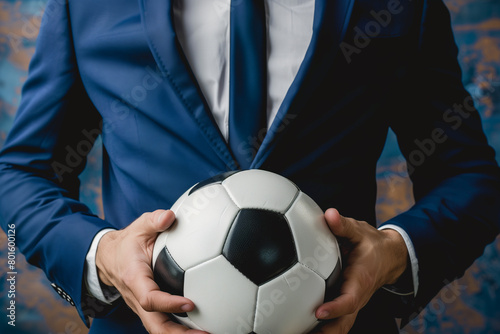 Man in Suit Holding Soccer Ball photo