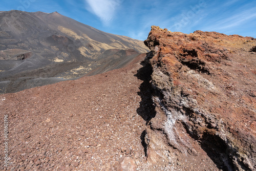 une roche rouge avec le sommet d'un volcan en arrière plan photo