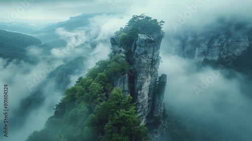 View of the Imperial Pen Peak in Zhangjiajie  enveloped in thick mist and lush greenery  offering a serene and mystical mountain landscape.