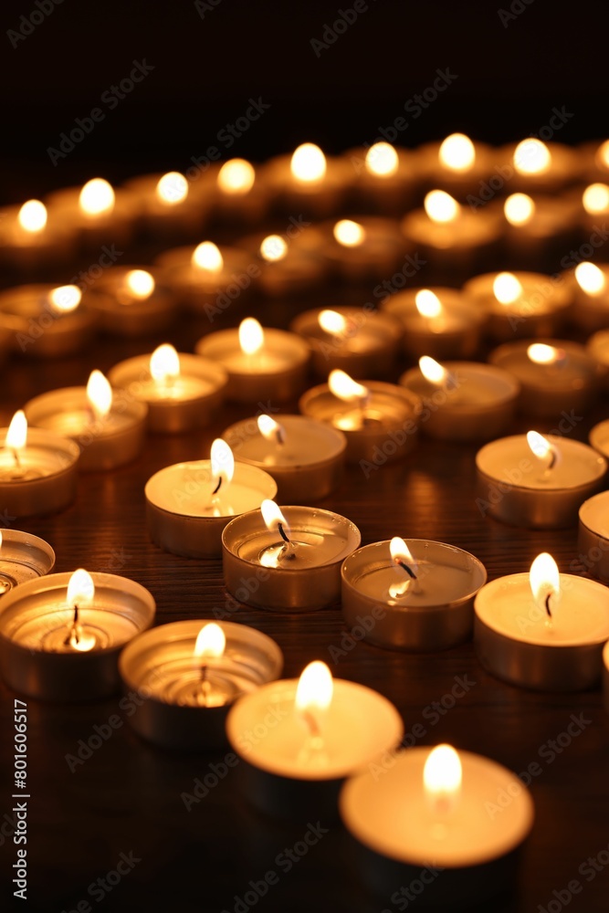 Burning candles on wooden table in darkness Burning candles on wooden table in darkness
