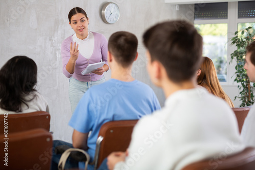 Young female professor explaining subject to group of students