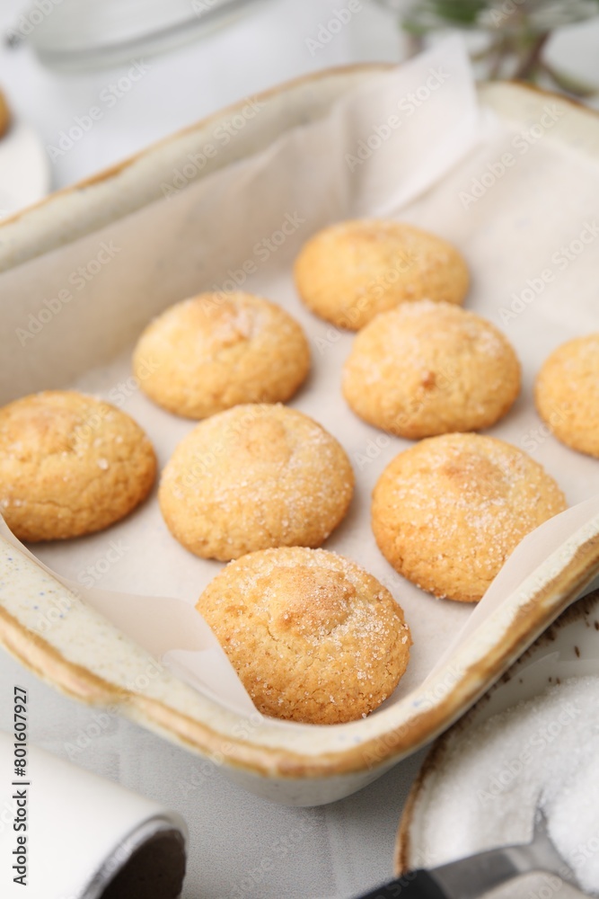 Tasty sweet sugar cookies in baking dish on white tiled table, closeup Tasty sweet sugar cookies in baking dish on white tiled table, closeup