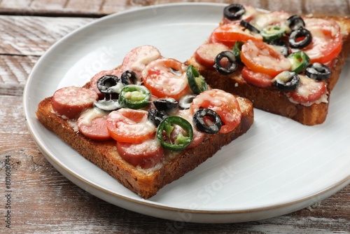 Tasty pizza toasts on wooden table, closeup