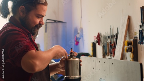 Mechanic in carpentry shop changing rotor part on spindle moulder machinery. Repairman in joinery fixing broken wood shaper  replacing damaged component  camera A close up shot