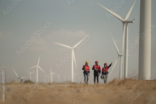 Young man and woman maintenance engineer team. two engineer operate wind turbine. Engineer and worker discussing on a wind turbine farm. Wind Turbine. Maintenance Workers. renewable energies..