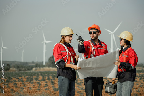 Young man and woman maintenance engineer team. two engineer operate wind turbine. Engineer and worker discussing on a wind turbine farm. Wind Turbine. Maintenance Workers. renewable energies.. photo