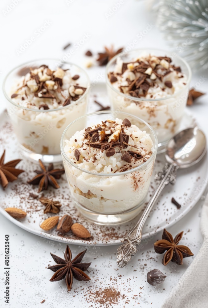 Festive dessert glasses filled with creamy layered pudding, topped with chopped nuts and chocolate shavings, surrounded by star anise. Festive dessert glasses filled with creamy layered pudding, topped with chopped nuts and chocolate shavings, surrounded by star anise.