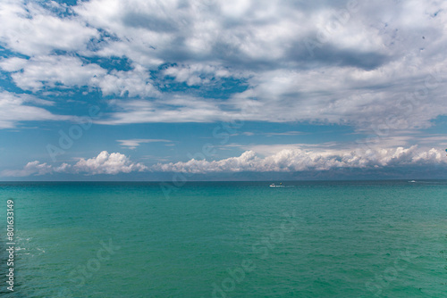 Beauty cloud against a blue sky background. Sky slouds. Blue sky with cloudy weather, nature cloud over the sea. Over the sea white clouds, blue sky and sun. High quality photo