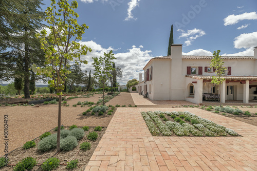 Newly planted gardens with terracotta and gravel floors in the patio of an Andalusian farmhouse style house photo
