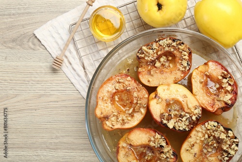 Fototapeta Naklejka Na Ścianę i Meble -  Delicious baked quinces with nuts in bowl, honey and fresh fruits on wooden table, flat lay. Space for text