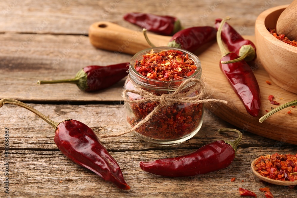 Chili pepper flakes and pods on wooden table Chili pepper flakes and pods on wooden table