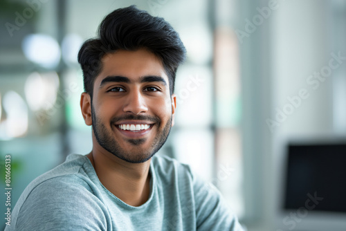 Portrait of a cheerful young man with a bright smile, exuding confidence and friendliness in a casual setting with soft natural light enhancing his approachable demeanor