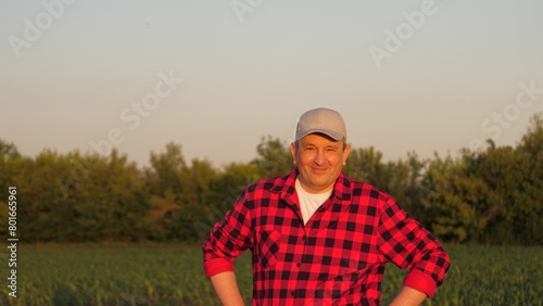 Portrait smiling man farmer posing at sunset sunny corn field countryside nature closeup. Male agronomist agricultural worker standing maize plantation organic harvest cultivation tree sky landscape © DREAM INSPIRATION