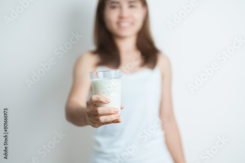 Milk drink and Daily Routine concept. Young woman Drinking milk with high calcium and nutrition at home, woman holding soy milk on glass with protein. Healthy, wellness and happy lifestyle © Jo Panuwat D