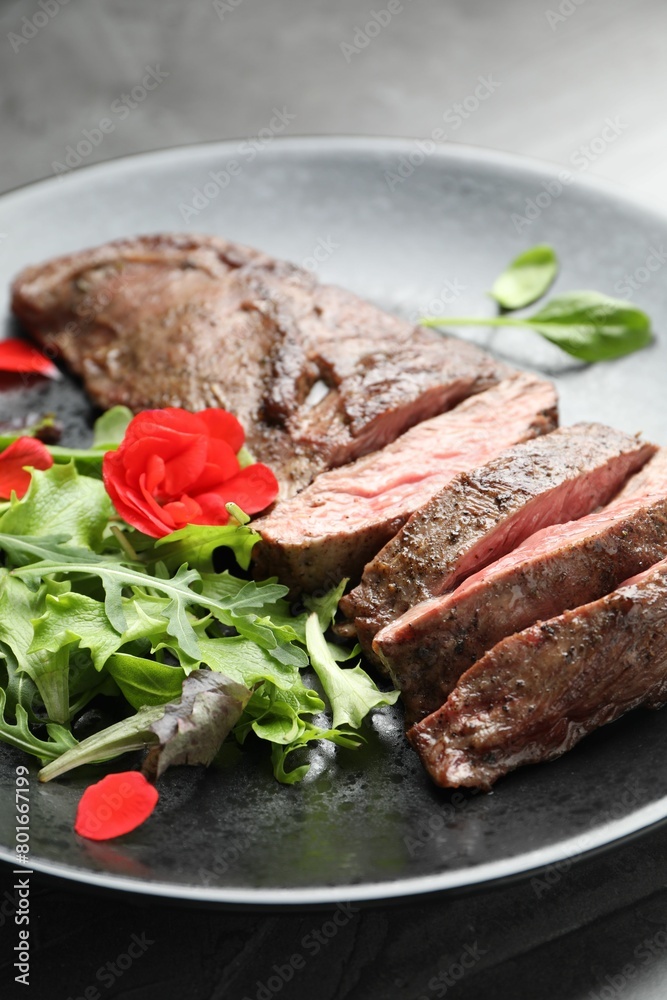 Pieces of delicious grilled beef meat and greens on table, closeup Pieces of delicious grilled beef meat and greens on table, closeup