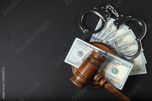 Law gavel, dollars and handcuffs on grey table, flat lay. Space for text photo