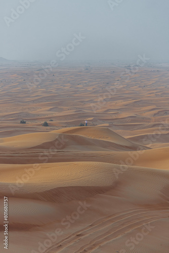 Dubai desert and a small man on the one of the hills