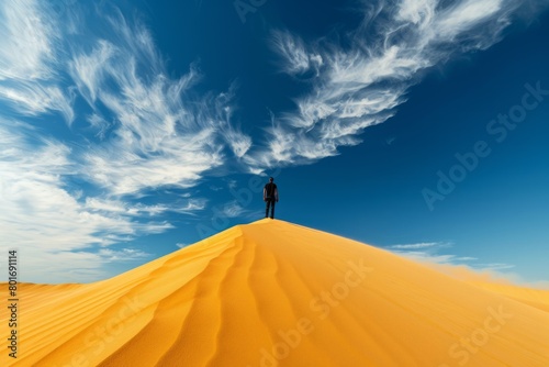 Fototapeta Naklejka Na Ścianę i Meble -  Footprints in the Dunes: A Man Trekking across a Sandy Hill in the Desert.