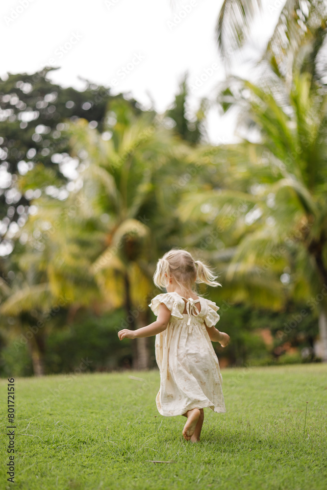 little girl running in the garden at sunset outdoor barefoot, tropical background little girl running in the garden at sunset outdoor barefoot, tropical background