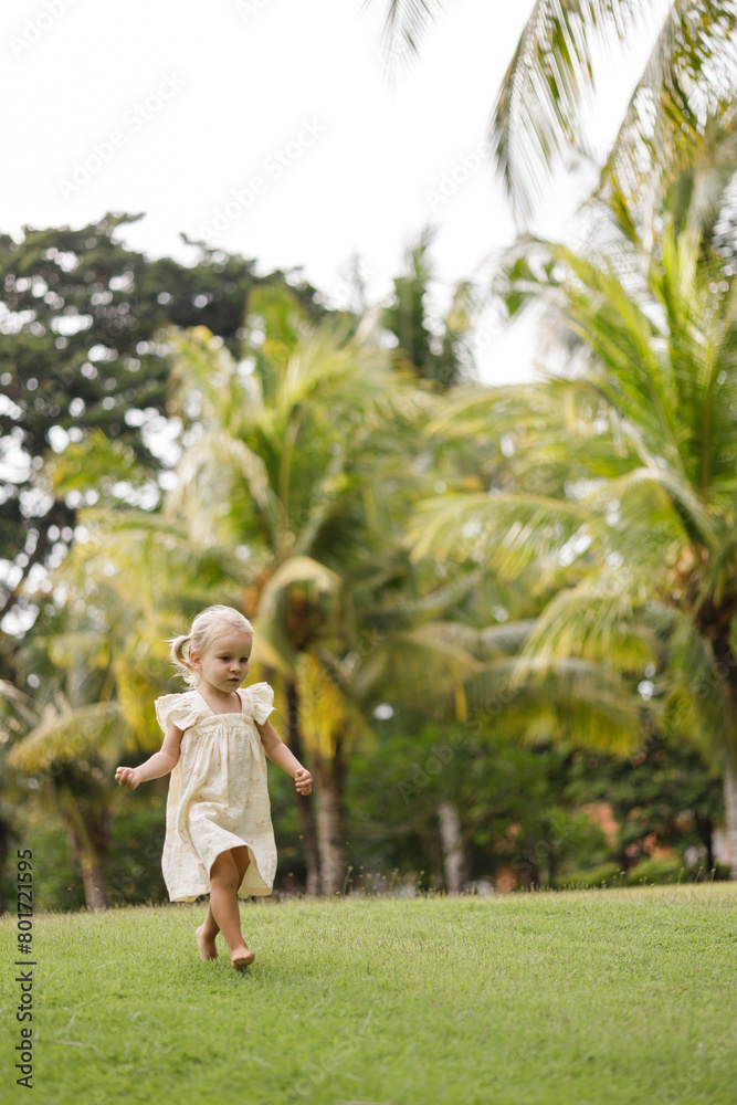 Happy cute little girl running on the grass in the park. Happiness., childhood Happy cute little girl running on the grass in the park. Happiness., childhood