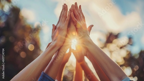 A group of people raise their hands up as a symbol of having achieved a success together.