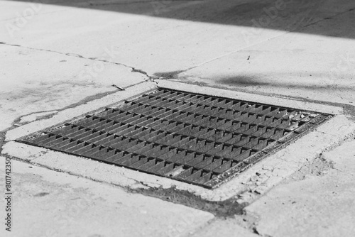 faded black street great on cracked concrete street from diagonal angle in an alley in black and white