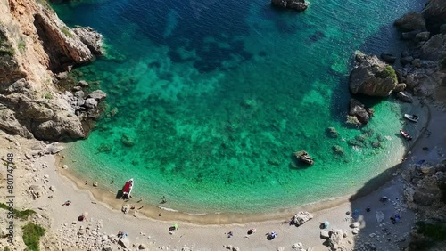 Giali beach in corfu with crystal-clear turquoise waters and sunbathers on sand, aerial view photo