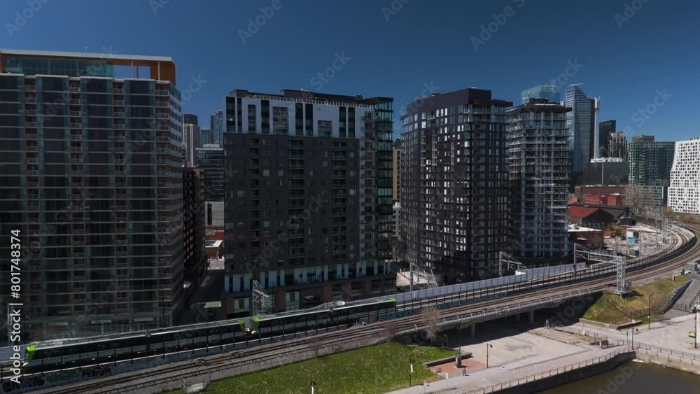 REM automated light rail system subway train in Montreal city with skyline building in Quebec, Canada aerial drone sunny day REM automated light rail system subway train in Montreal city with skyline building in Quebec, Canada aerial drone sunny day