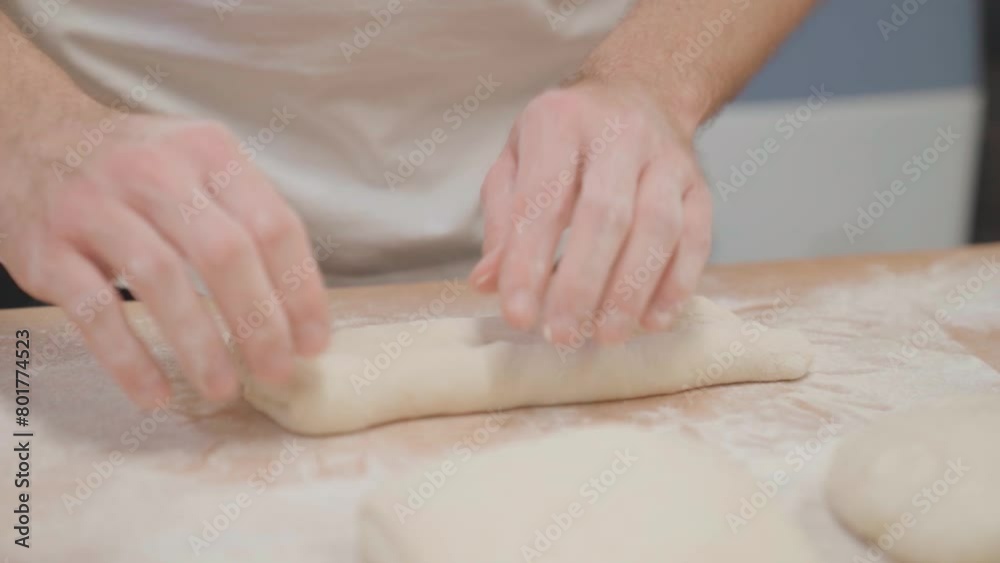 Baker preparing fresh dough for baguette, hands close up Baker preparing fresh dough for baguette, hands close up