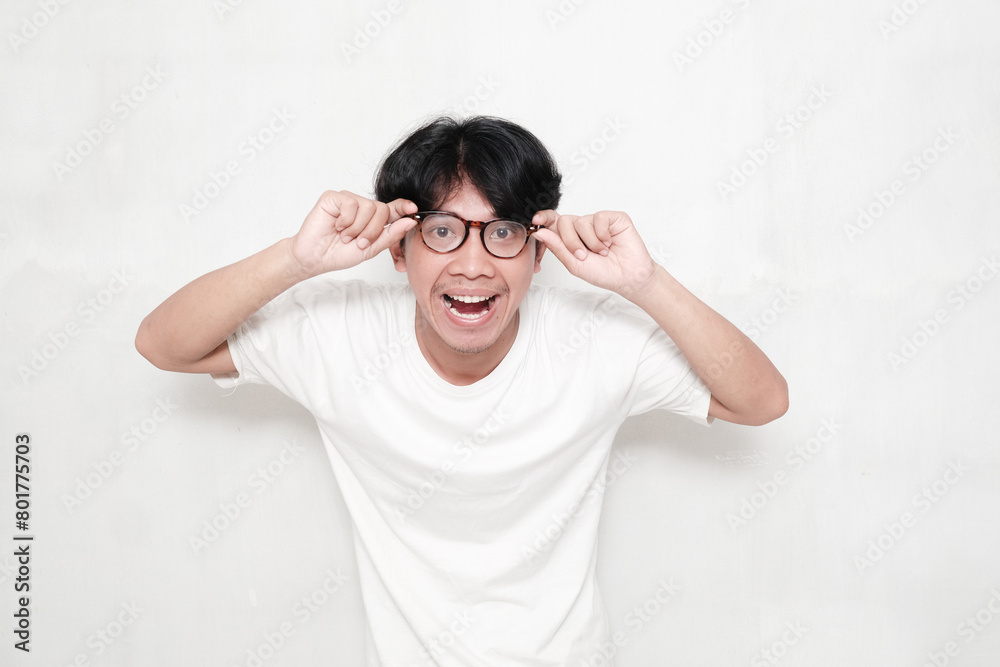 Asian man, holding and wearing glasses with smile isolated on background Asian man, holding and wearing glasses with smile isolated on background