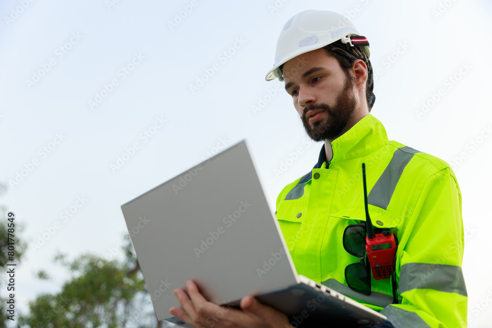 Engineer wearing safety uniform holding laptop discussed plan about renewable energy at station energy power wind. technology protect environment reduce global warming problems. Engineer wearing safety uniform holding laptop discussed plan about renewable energy at station energy power wind. technology protect environment reduce global warming problems.
