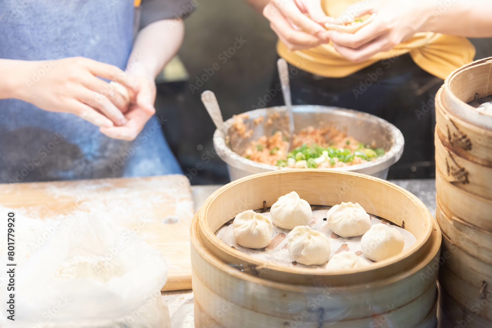 Fototapeta premium Mother teaching daughter to make Xiao Long Bao Local food of Asian countries Family food, street food, steamed Chinese food