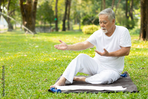 asian senior man workout and doing yoga in the park © offsuperphoto