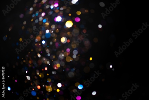 Colorful falling glitter sequin confetti on black background
