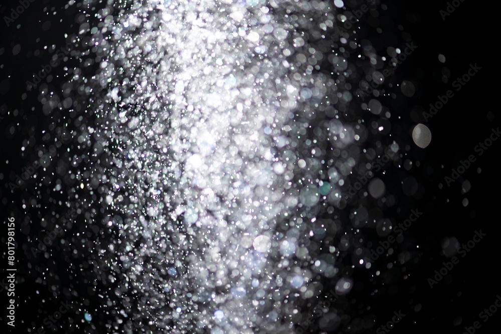 Obraz premium White falling glitter sequin confetti on dark black background