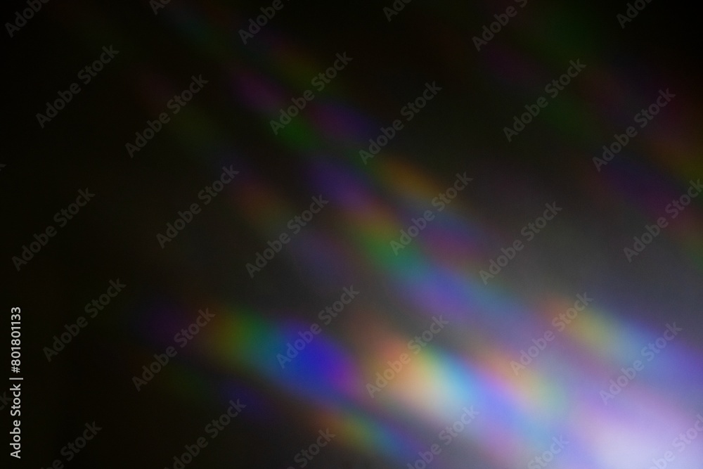 Iridescent rainbow prism light flare on black background