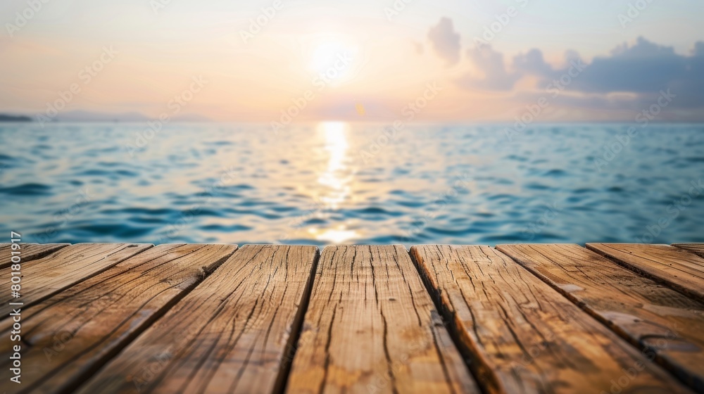 Stunning sunset view from a rustic wooden pier extending over a calm ocean.