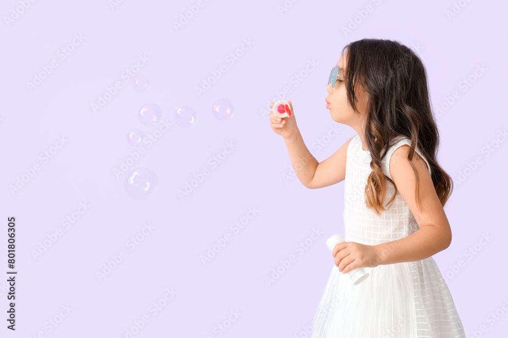 Cute little girl blowing soap bubbles on lilac background Cute little girl blowing soap bubbles on lilac background