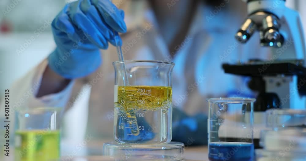 Flask containing a yellow oily liquid is added to liquid to conduct a chemical experiment