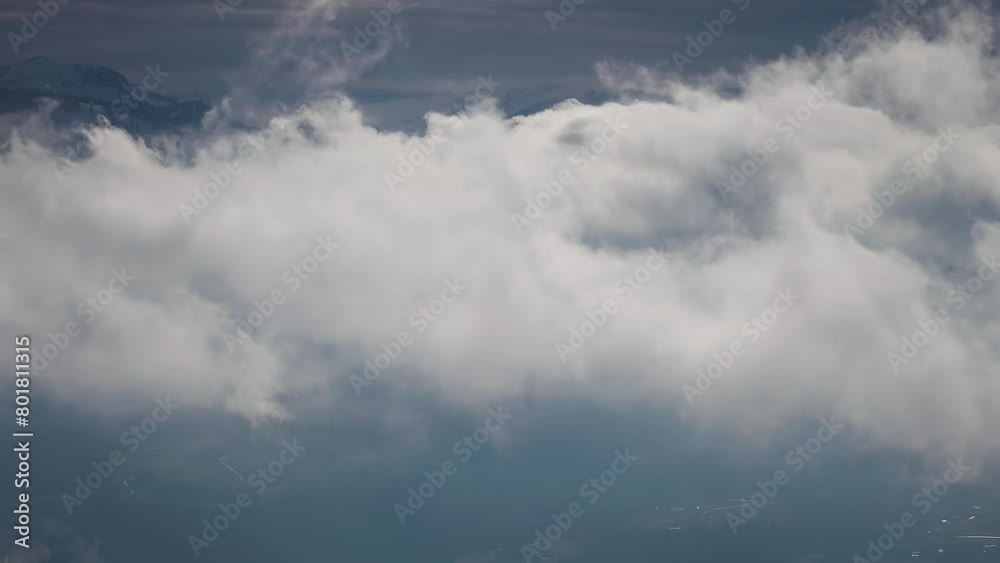 Flight through the dense white clouds whirling above the snow-capped mountains and a gloomy dark valley. Flight through the dense white clouds whirling above the snow-capped mountains and a gloomy dark valley.