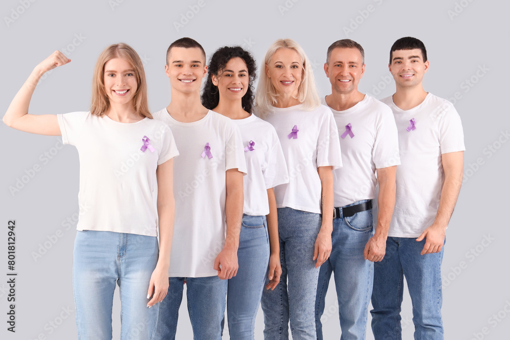 People with lavender awareness ribbons on light background. World Cancer Day People with lavender awareness ribbons on light background. World Cancer Day
