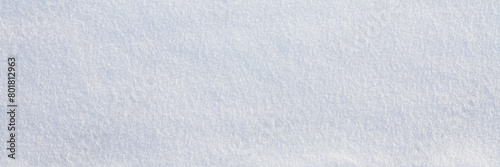 Natural snow texture. Smooth surface of clean fresh snow. Snowy ground. Winter background with snow patterns. Closeup top view. Wide panoramic texture for background and design.