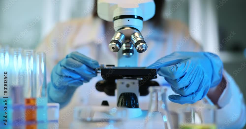 Closeup of microscope with lens and laboratory glass setup